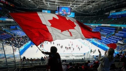 A fan waves a Canadian flag following a men's qualification round hockey game between Canada and China at the 2022 Winter Olympics, Tuesday, Feb. 15, 2022, in Beijing. Canada won 7-2.