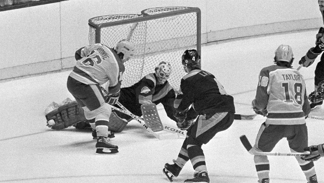 Los Angeles Kings' Marcel Dionne (16) slaps puck into net to score his 400th career goal during first period of game in Los Angeles, Dec. 4, 1980. Vancouver Canucks goalie Gary Bremley (30) and teammate Rick Lanz were unable to defend.