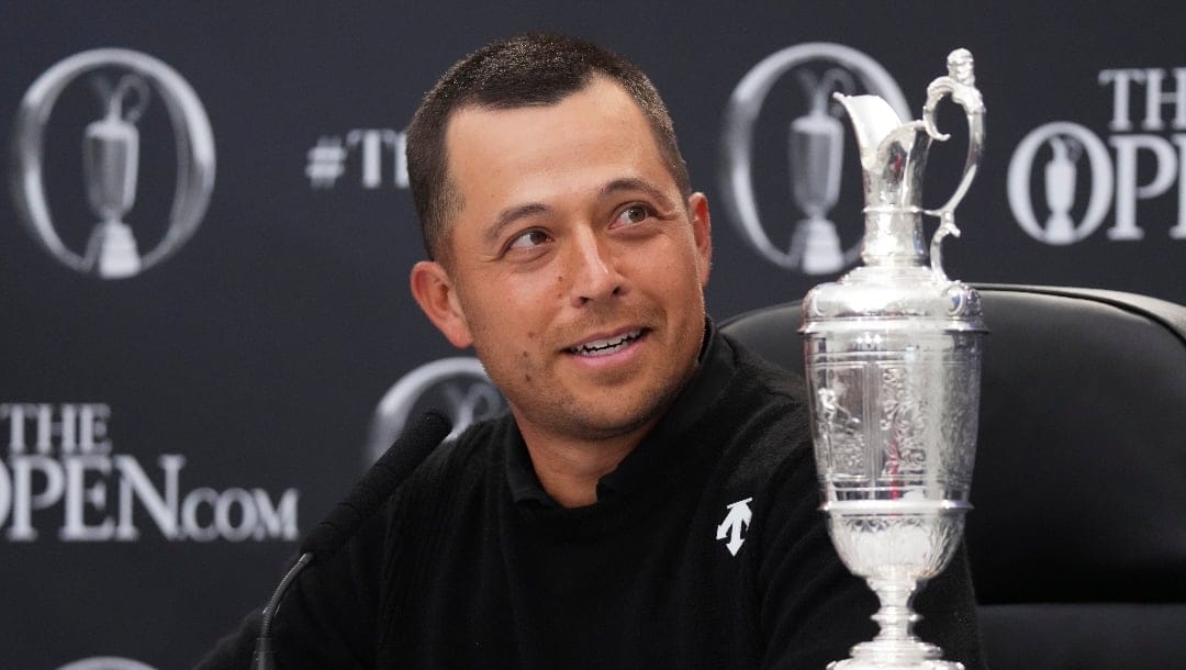 Xander Schauffele of the United States reacts as he sits with the Claret Jug trophy at a press conference after winning the British Open Golf Championships at Royal Troon golf club in Troon, Scotland, Sunday, July 21, 2024. (AP Photo/Jon Super)