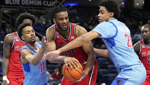 St. John's forward Zuby Ejiofor, center, rebounds a ball against DePaul guard CJ Gunn, left, and forward Theo Pierre-Justin during the second half of an NCAA college basketball game in Chicago, Wednesday, Feb. 19, 2025.