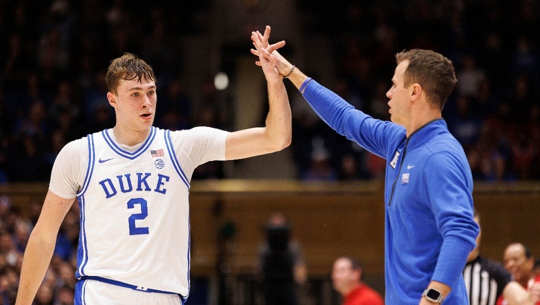 Duke's Cooper Flagg (2) high-fives head coach Jon Scheyer, right, during the second half of an NCAA college basketball game against North Carolina State in Durham, N.C., Monday, Jan. 27, 2025. (AP Photo/Ben McKeown)