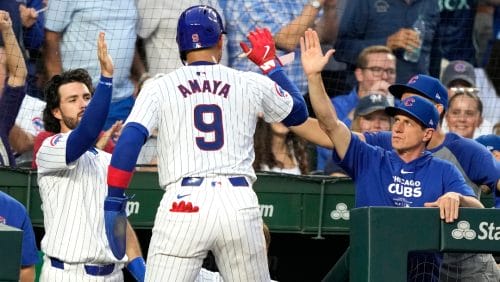 Chicago Cubs' Miguel Amaya is greeted at the dugout by Dansby Swanson, left, and manager Craig Counsell, right, after Amaya scored on Michael Busch's single during the third inning of a baseball game against the Milwaukee Brewers Monday, July 22, 2024, in Chicago.