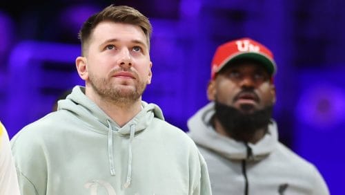 Luka Doncic #77 and LeBron James #23 of the Los Angeles Lakers look on before the second half of a game against the Indiana Pacers at Crypto.com Arena on February 08, 2025 in Los Angeles, California.