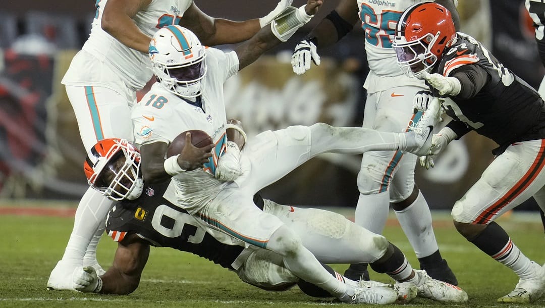 Cleveland Browns defensive end Myles Garrett, left, sacks Miami Dolphins quarterback Tyler Huntley, right, in the second half of an NFL football game in Cleveland, Sunday, Dec. 29, 2024.