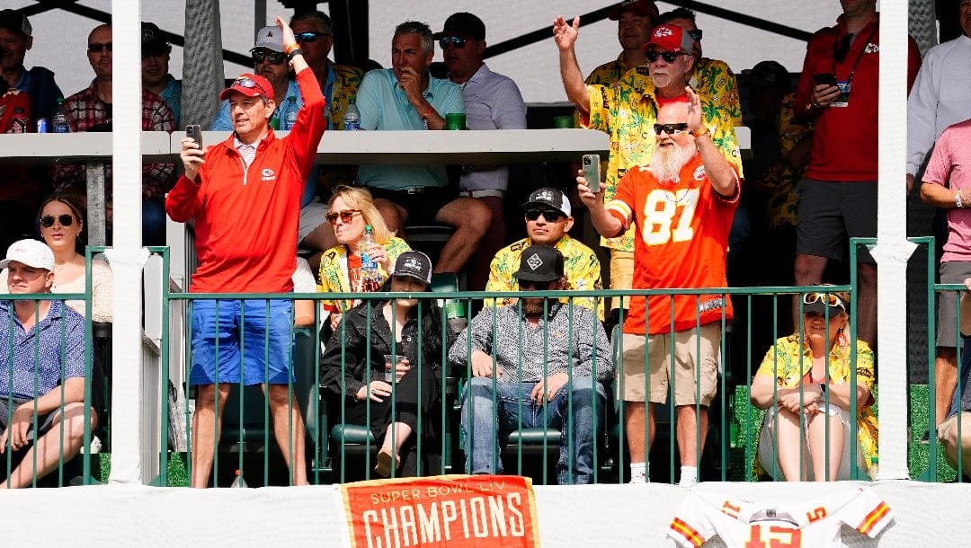 Kansas City Chief fans do the "tomahawk chop" on the 16th hole as a golfer dressed in red makes his way to the green during the final round of the Phoenix Open golf tournament, Sunday, Feb. 12, 2023, in Scottsdale, Ariz.