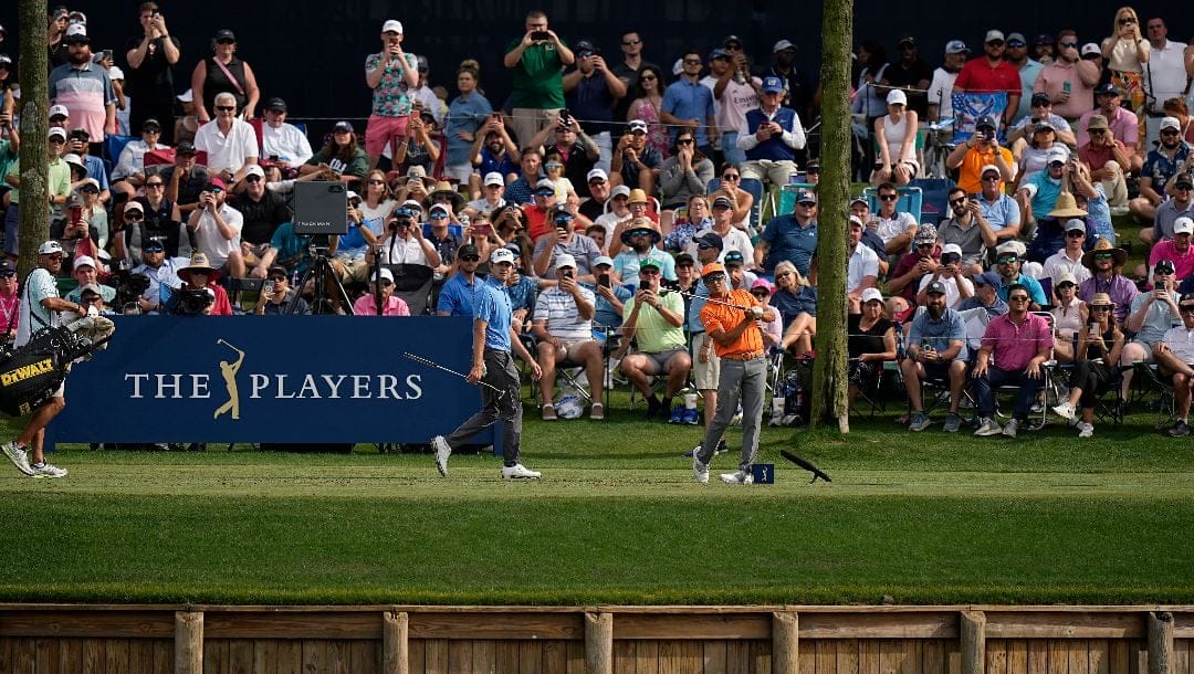 Rickie Fowler, foreground right, watches his shot from the 17th tee during the final round of The Players Championship golf tournament, Sunday, March 12, 2023, in Ponte Vedra Beach, Fla.