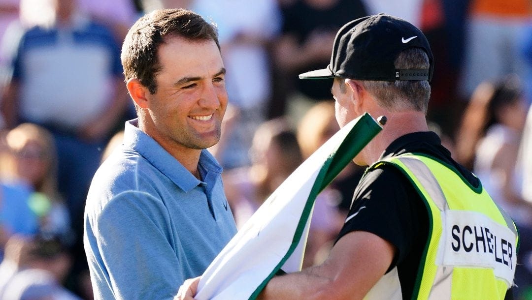 Scottie Scheffler greets his caddie Ted Scott after winning the Phoenix Open golf tournament, Sunday, Feb. 12, 2023, in Scottsdale, Ariz. Scheffler finished at 19 under par.