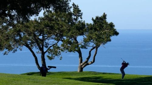 Collin Morikawa hits his second shot on the 14th hole of the North Course at Torrey Pines during the first round of the Farmers Insurance Open golf tournament, Wednesday, Jan. 25, 2023, in San Diego.