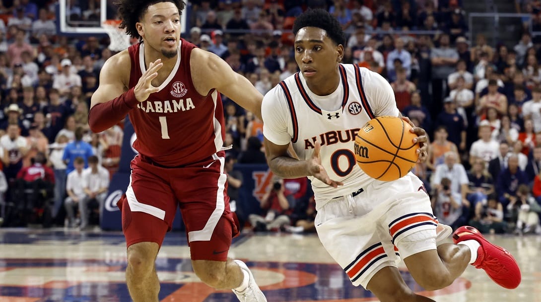 Auburn guard Tahaad Pettiford (0) drives to the basket around Alabama guard Mark Sears (1) during the second half of an NCAA college basketball game, Saturday, March 8, 2025, in Auburn, Ala.