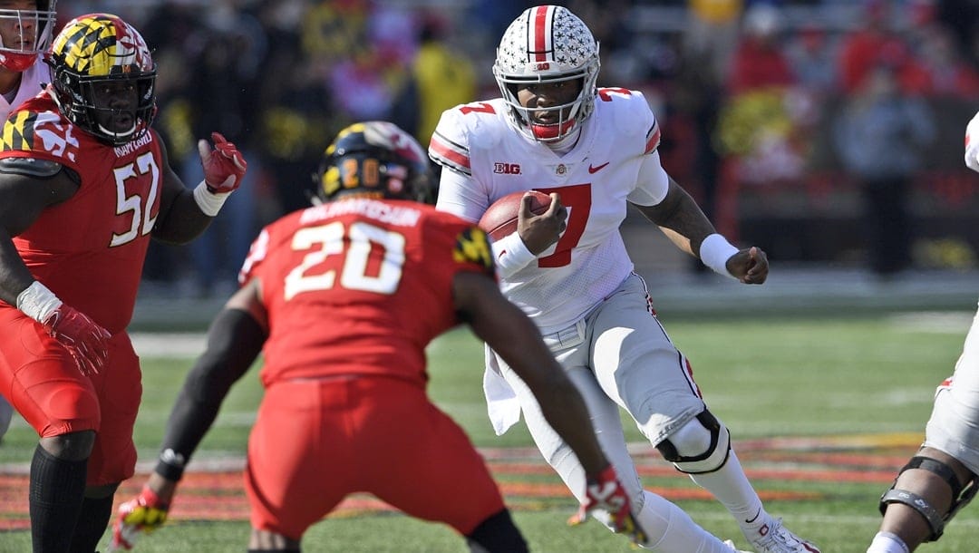 In this Saturday, Nov. 17, 2018, file photo, Ohio State quarterback Dwayne Haskins Jr. (7) runs with the ball against Maryland defensive back Antwaine Richardson (20) and defensive lineman Oluwaseun Oluwatimi (52) during the first half of an NCAA football game in College Park, Md. Ohio Stat coach Urban Meyer, says Haskins wasn’t a fully legitimate leader until he showed he was willing to run the ball two weeks ago in the narrow overtime win over Maryland.