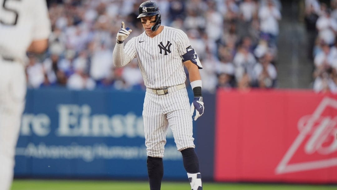 New York Yankees' Aaron Judge (99) gestures to teammates after hitting a ground-rule double during the first inning of a baseball game against the New York Mets Sunday, May 18, 2025, in New York.