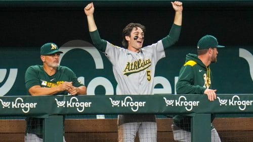 Oakland Athletics' Jacob Wilson (5) reacts in the dugout after teammate Brent Rooker hit a two-run home run off Texas Rangers pitcher Luke Jackson during the ninth inning of a baseball game Wednesday, April 30, 2025, in Arlington, TX.