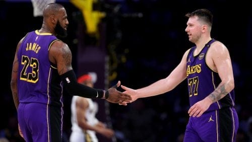 LeBron James #23 and Luka Doncic #77 of the Los Angeles Lakers shake hands against the New Orleans Pelicans during the second quarter at Crypto.com Arena on April 04, 2025 in Los Angeles, California.